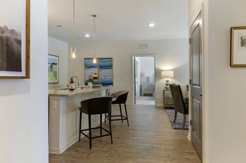 A kitchen with a bar area and a painting on the wall.